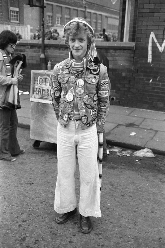 Manchester United Fan with Badges and Hat (wider shot) by Iain SP Reid - 1976