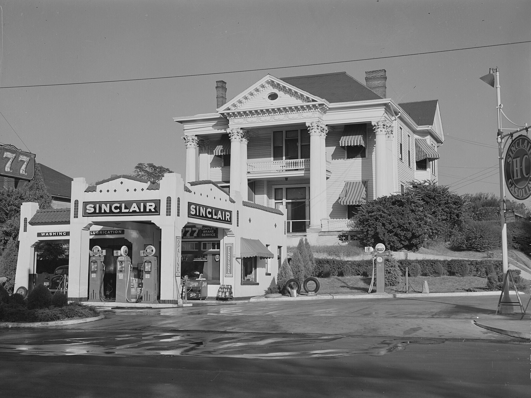 Gas station in front of an old colonial house in Jackson, Mississippi Delta, Mississippi by Marion Post Wolcott, 1939