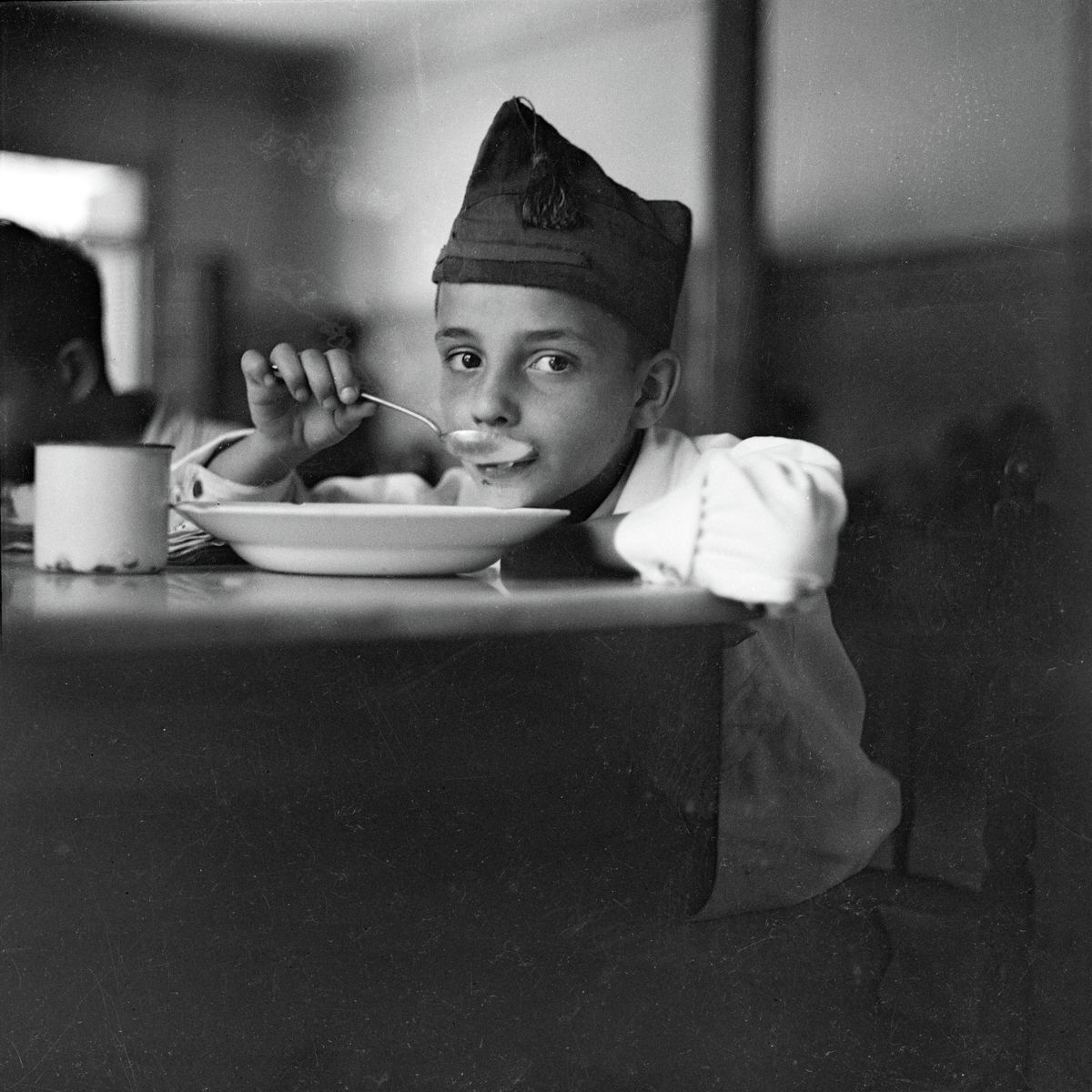 Child looking up from eating soup, Madrid by Gerda Taro - 1936-37