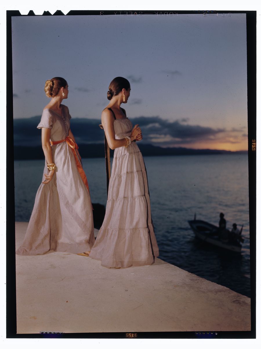 Two women in evening gowns posed in front of water at sunset Nov 1946 Toni Frissell