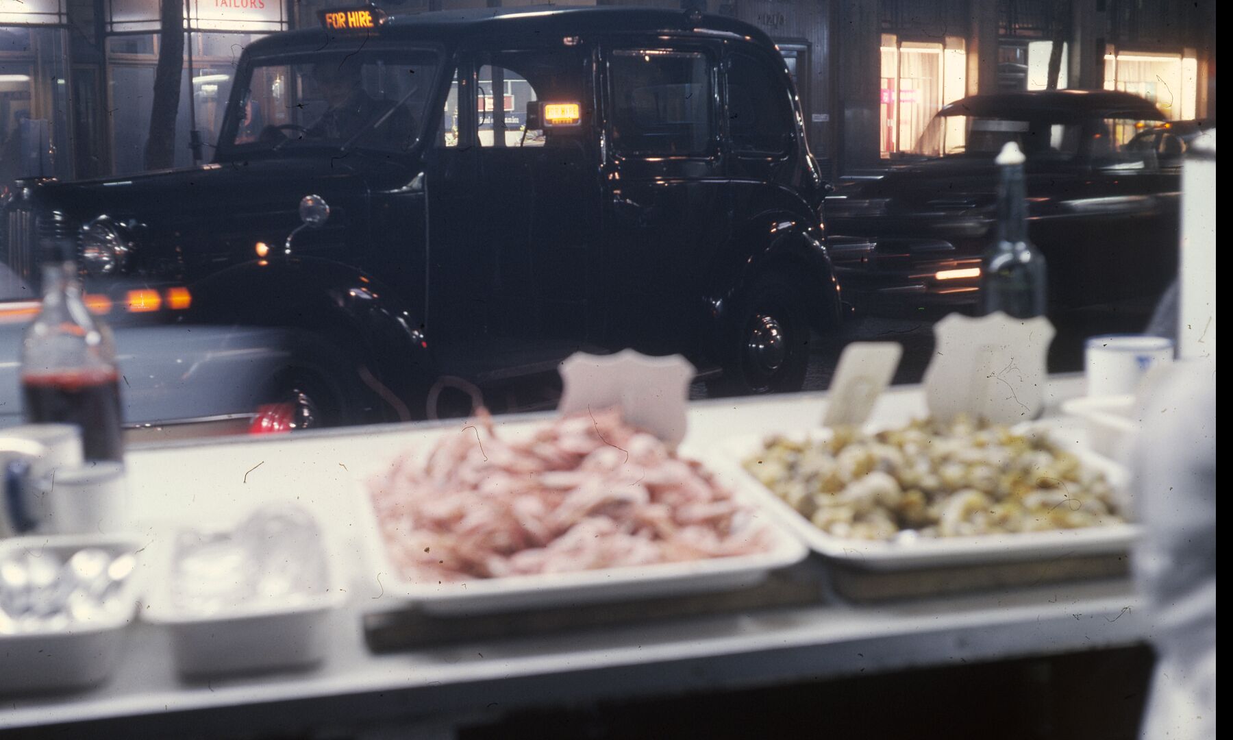 London Cabs and Seafood by Bob Hyde. Taken in the West End of London in the 1960s.
