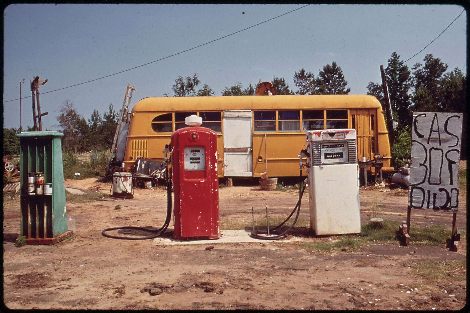 Cut-Rate Gas Station Operates Out of Bus by Marc St. Gil - June 1972 