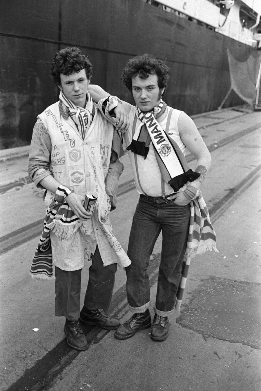Two Manchester United Fans in Front of A Ship by Iain SP Reid - c. 1976