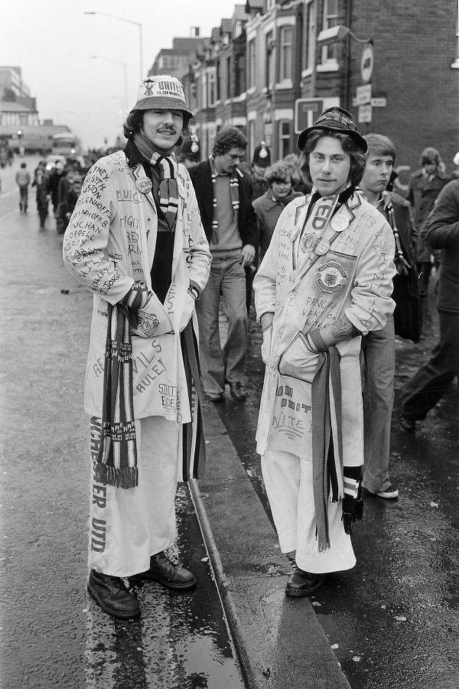 Two Manchester United Fans in Butcher Coats by Iain SP Reid - c. 1976