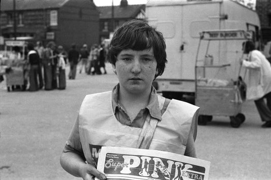Garçon vendant le papier de football rose à Manchester par Iain SP Reid - ch. 1976.