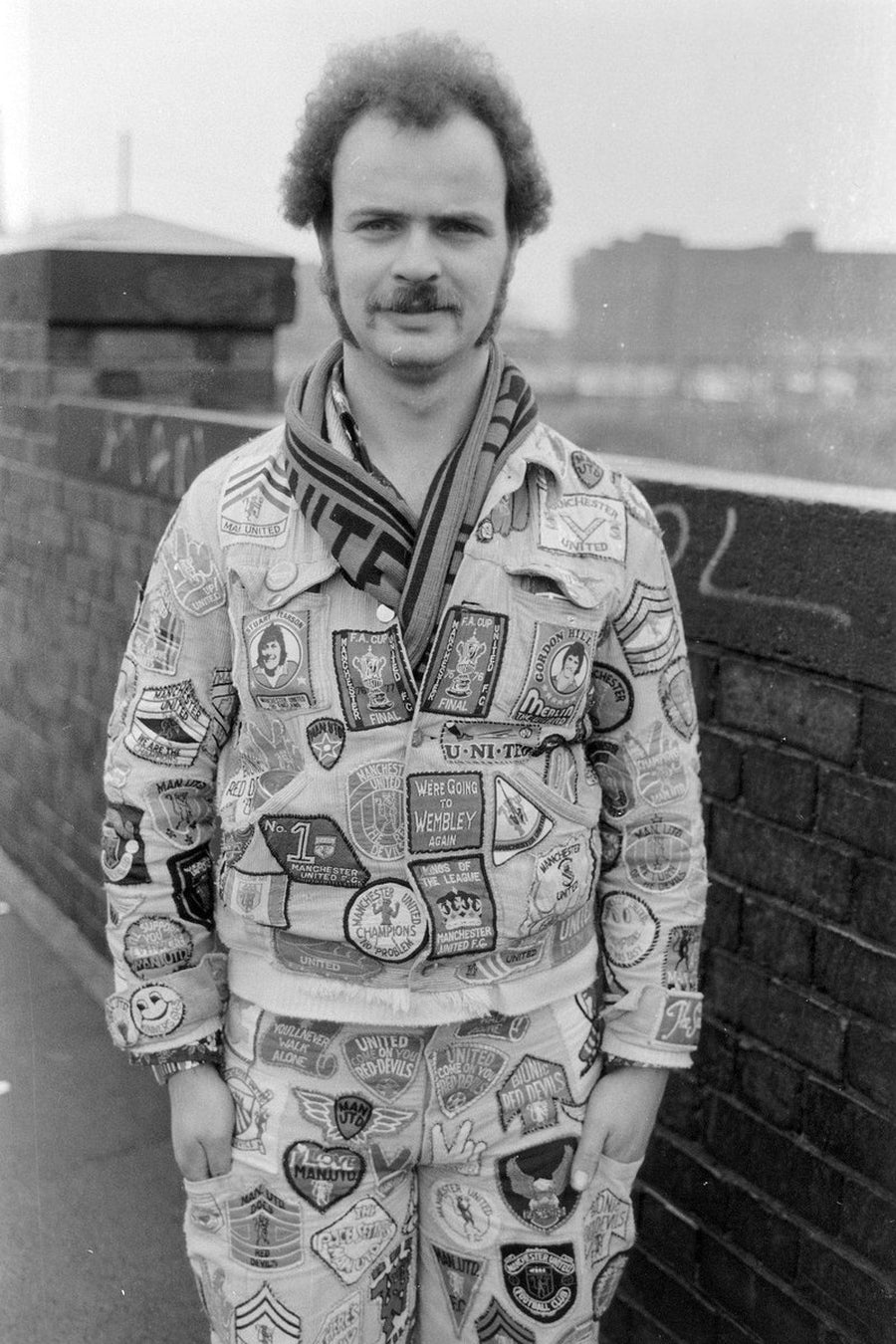 Manchester United Fan with Badges by Iain S. P. Reid, c. 1977. Copyright: Estate of Iain S.P. Reid. Not to be used for any purpose without permission