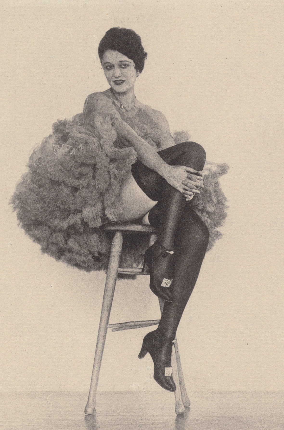 Femme en costume de Can Can assise sur un tabouret par Arthur F. Kales vers 1920 - Carte postale