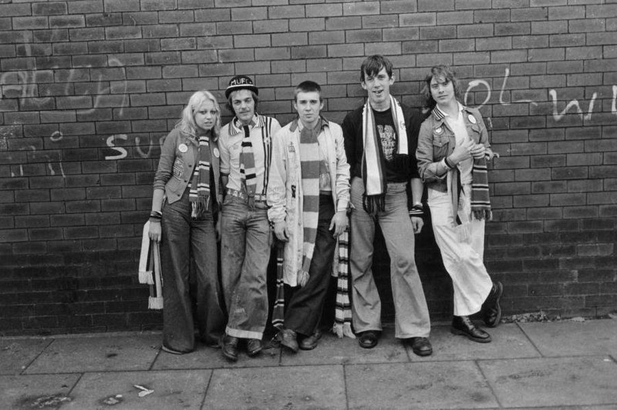 Groupe de fans de Manchester United contre un mur de briques par Iain SP Reid, ch. 1977.
