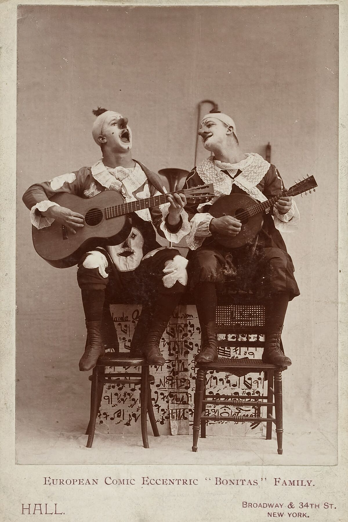 Cabinet card image of two performers playing stringed instruments. Labeled 'European comic eccentric 'Bonitas' family'.  Harvard Theatre Collection, Harvard University 1918 or earlier