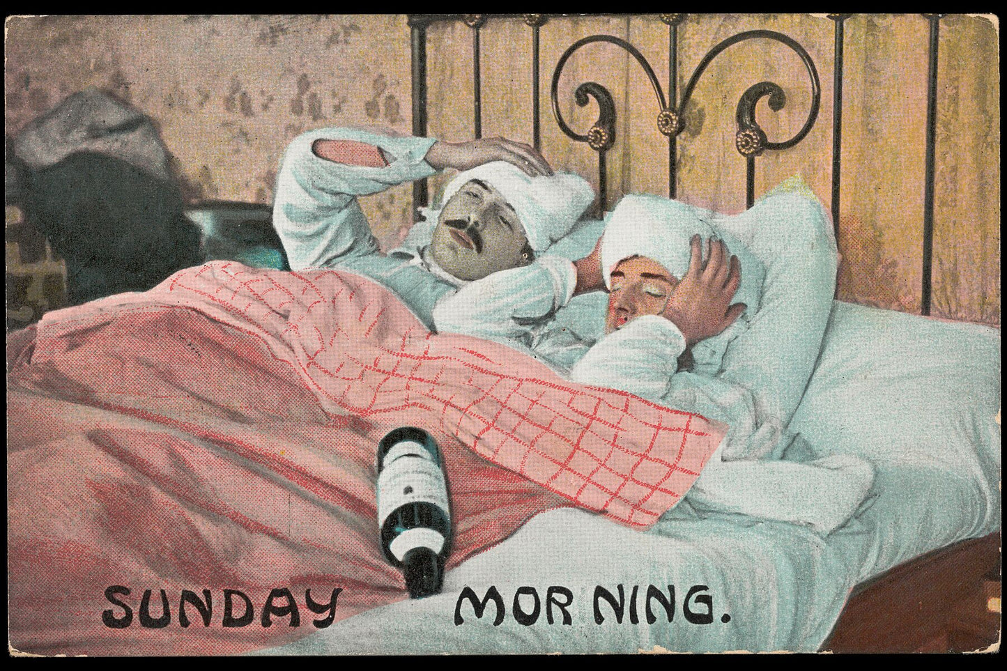 Two men in bed on a Sunday Morning after drinking from a bottle of alcohol. Colour process print, ca. 1908 postcard