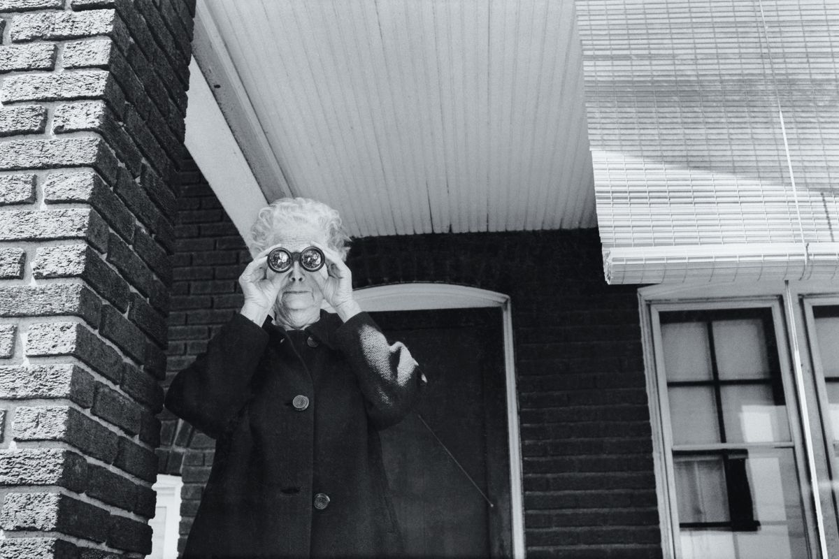 Woman Looking at a Parade from her Front Porch in Ohio by Michael Carlebach - 1972
