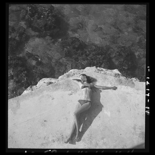 Fashion model Natahli (Natalie) Nickerson Paine a wearing bikini, lying on platform near water, Montego Bay, Jamaica November 1946 Toni Frissell